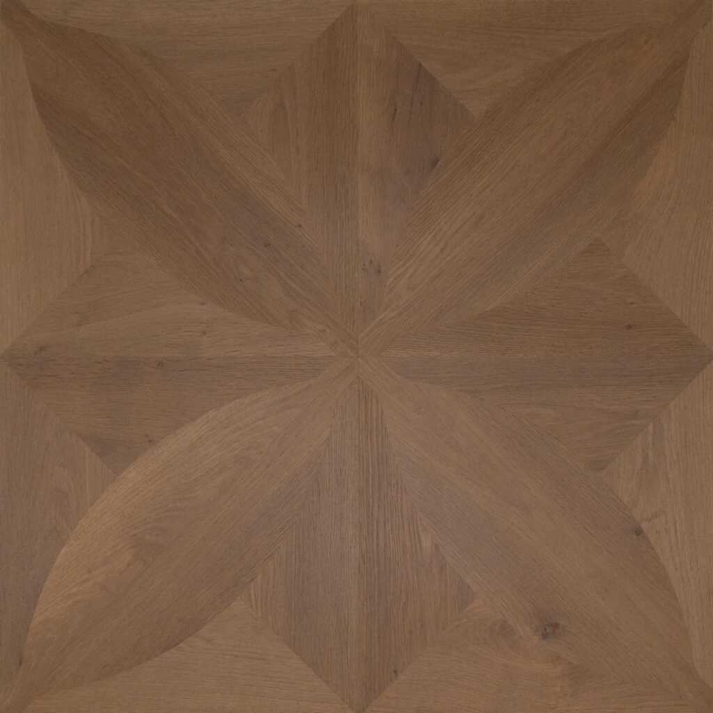 A close-up of a geometric wood inlay pattern with a warm medium brown tone and visible wood grain.