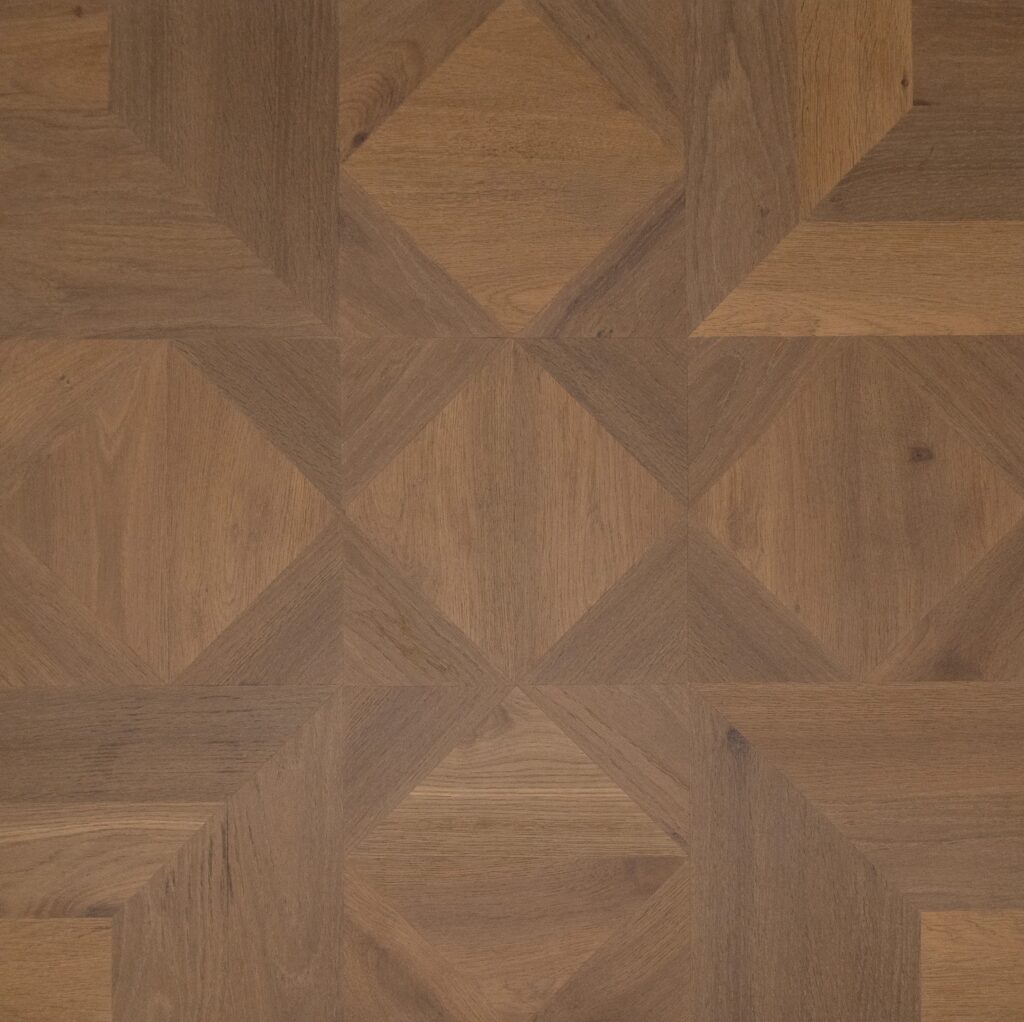 Geometric parquet wood flooring pattern in warm medium brown tones with visible natural wood grain.