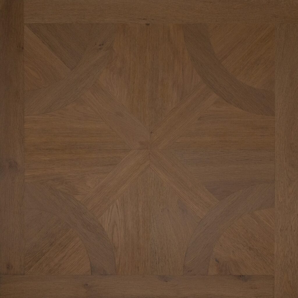 A close-up of a medium brown wood parquet floor pattern with geometric grain and curved inlay details.