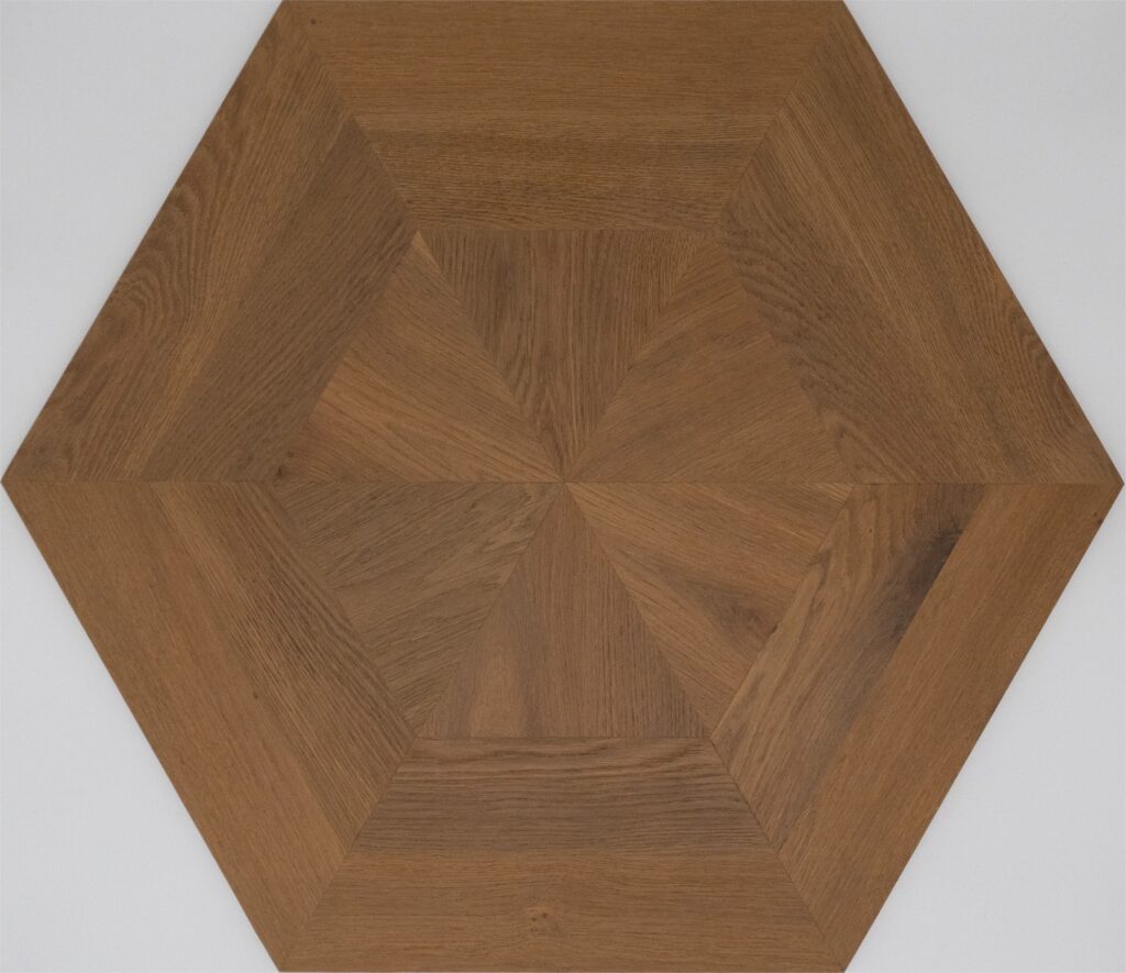 Hexagonal wood flooring tile with a geometric starburst inlay pattern in medium brown tones, shown against a neutral light gray background.